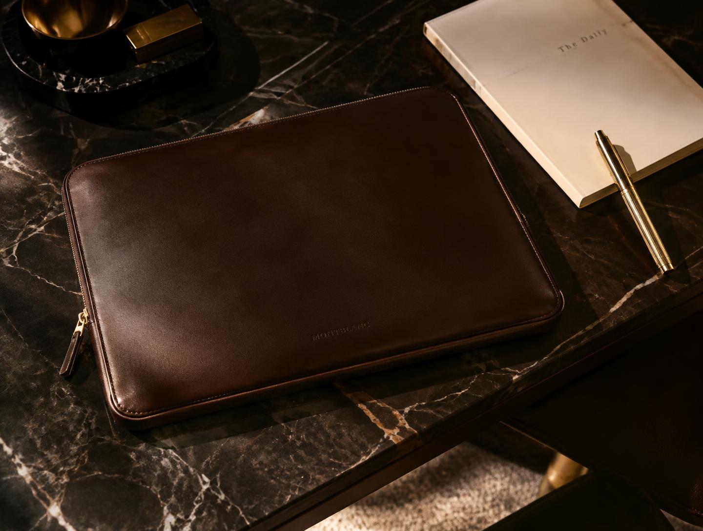 Espresso leather laptop sleeve on dark marble